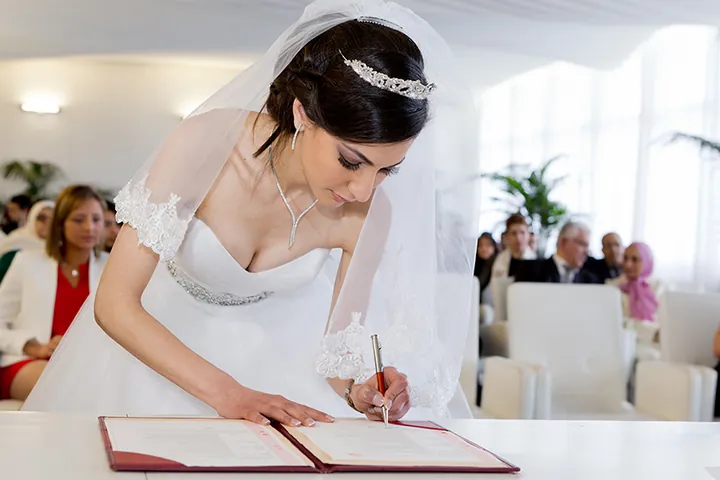 Mariée qui signe le registre de mariage